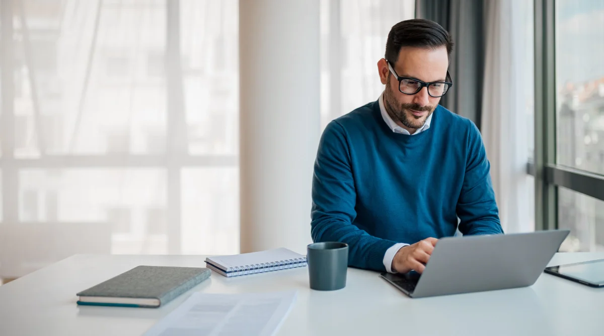 Man working on a laptop in a bright office space