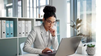 Professional focused on a laptop in a modern office