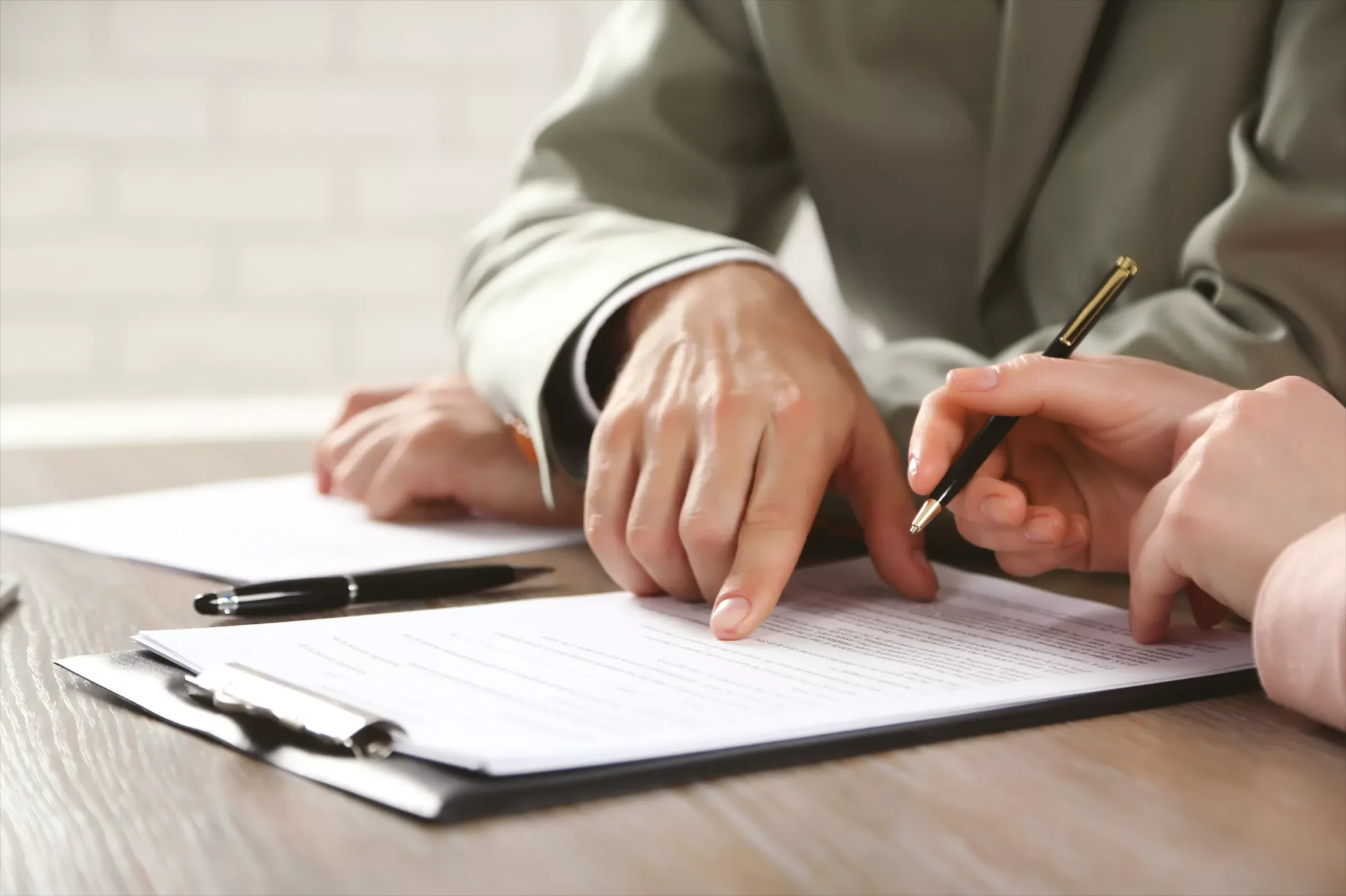 A picture showing a professional helping a woman to create her financial and asset management document, while clarifying how to add the per stirpes distribution clause in the document.