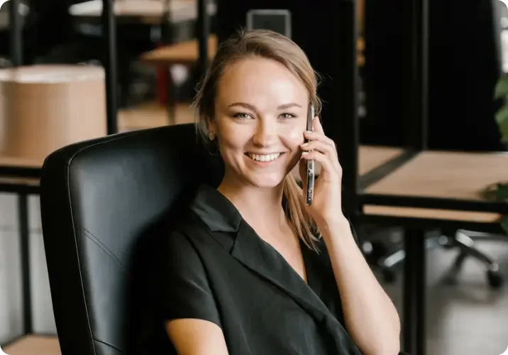 A woman with blond hair sits at her desk and answers calls 