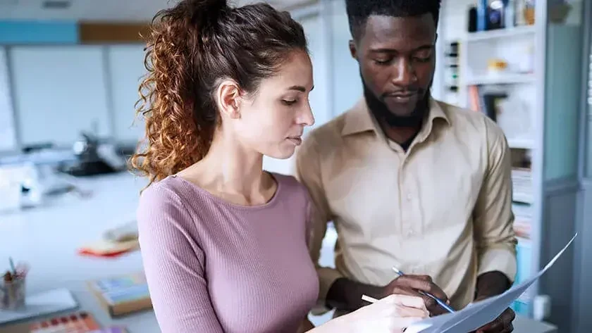 A woman and a man are looking at the paperwork.