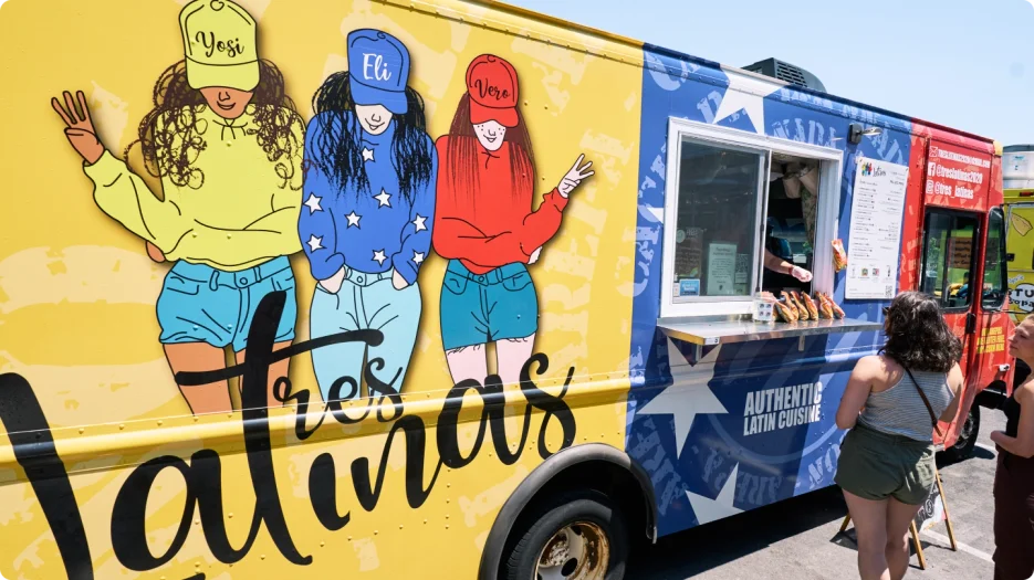 Colorful mural of three girls on a yellow truck
