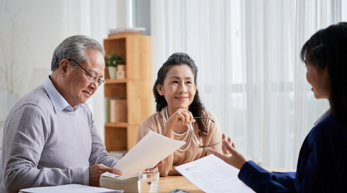A couple sits in an office and reviews their will with their estate planning lawyer.