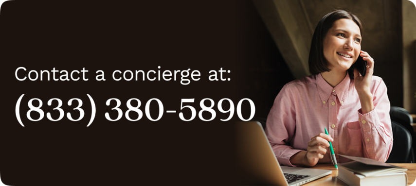 Woman in a pink blouse sitting at her desk, talking on the phone