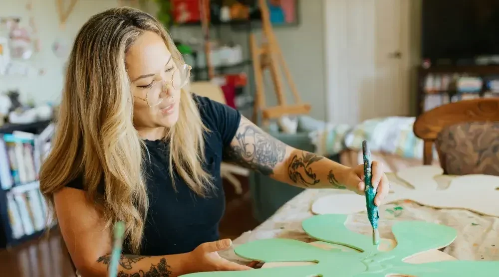 A small business owner works on an art piece in her Hawaii studio.
