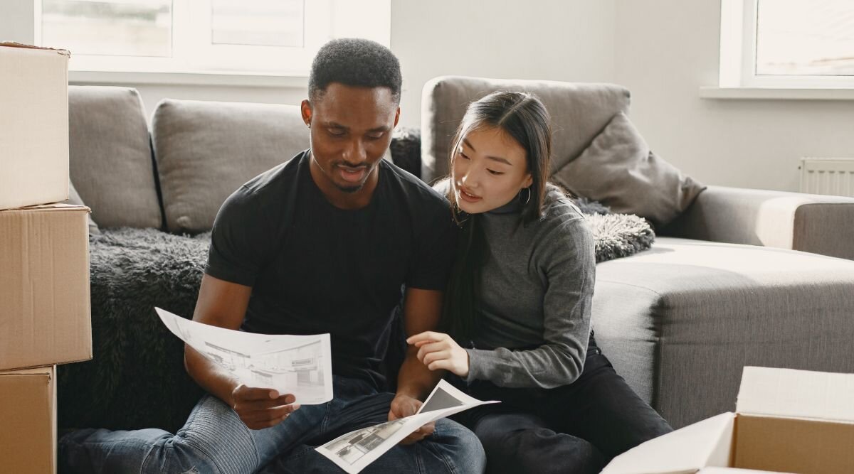 A couple sits in the living room of their new home while they review items from their virtual mailbox.