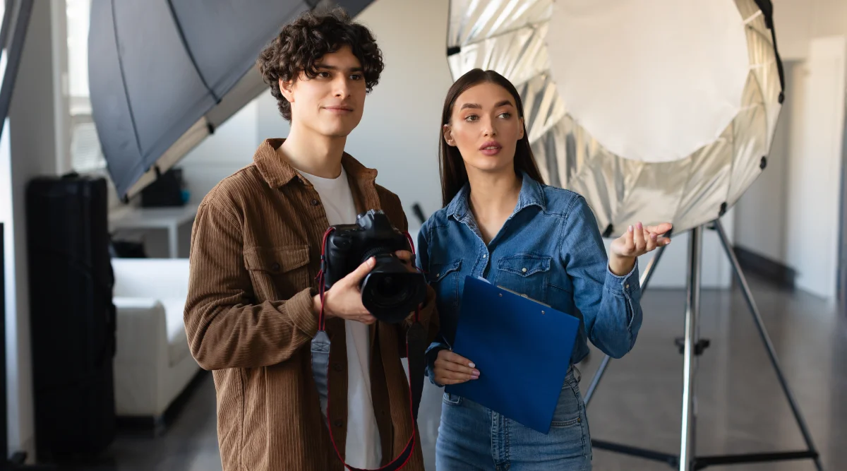 Young man and woman have a creative conversation on the set of a photography shoot. 