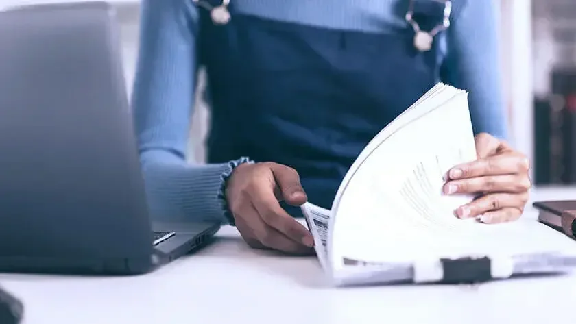 A woman going through a stack of essential estate planning documents.