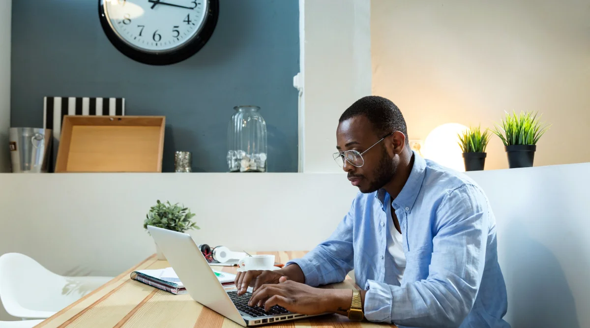 Man focused on a laptop in a minimalist workspace