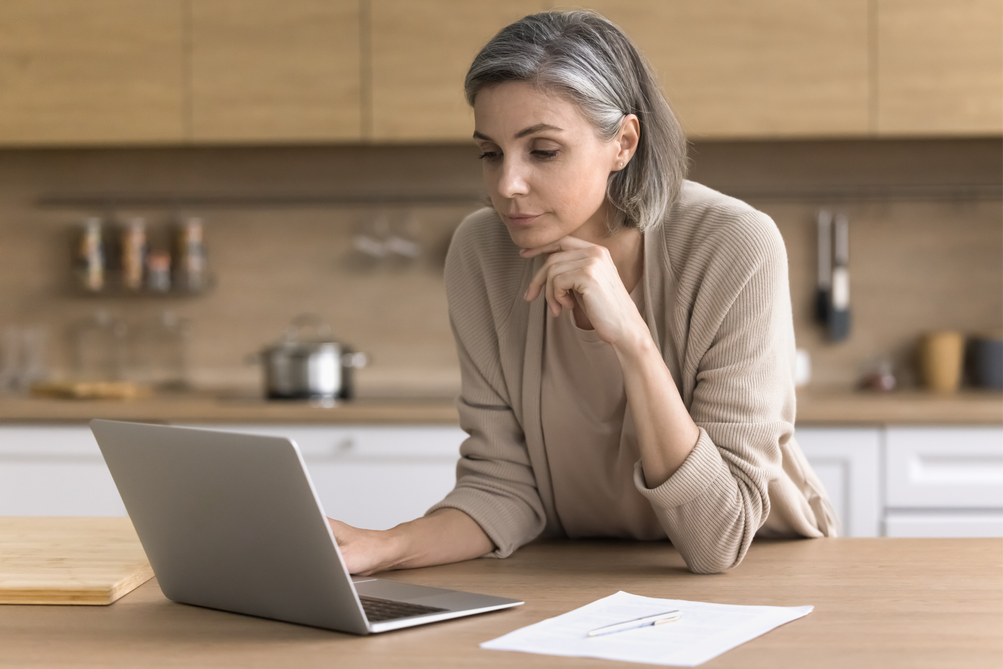 A woman is researching the role of a grantor in a trust on her laptop.