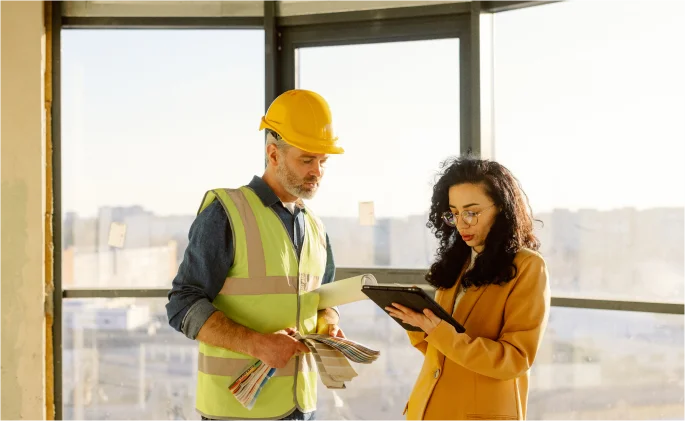 Man and woman discuss a construction project 