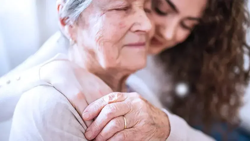 A woman and her mother embrace lovingly