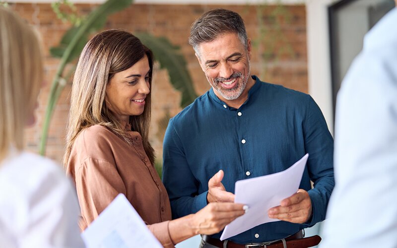 An image of a couple pointing and looking at a security agreement happily.