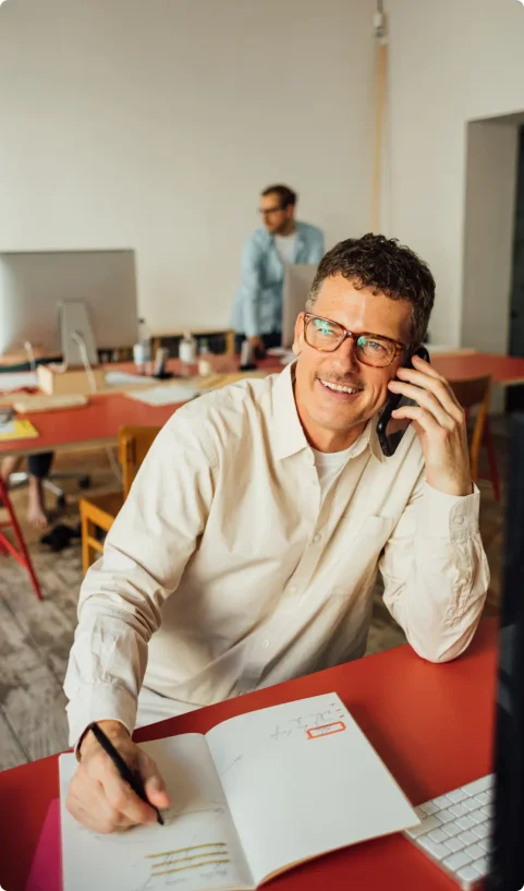 A man works and chats on the phone in a cafe
