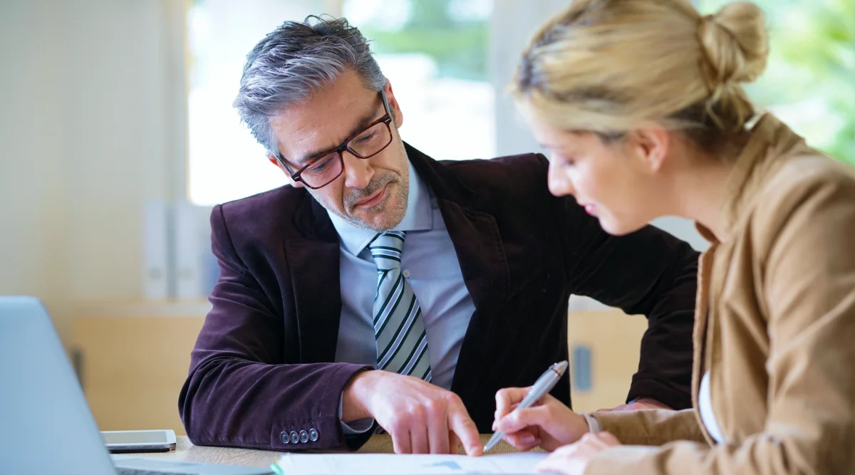 A man and woman review papers together