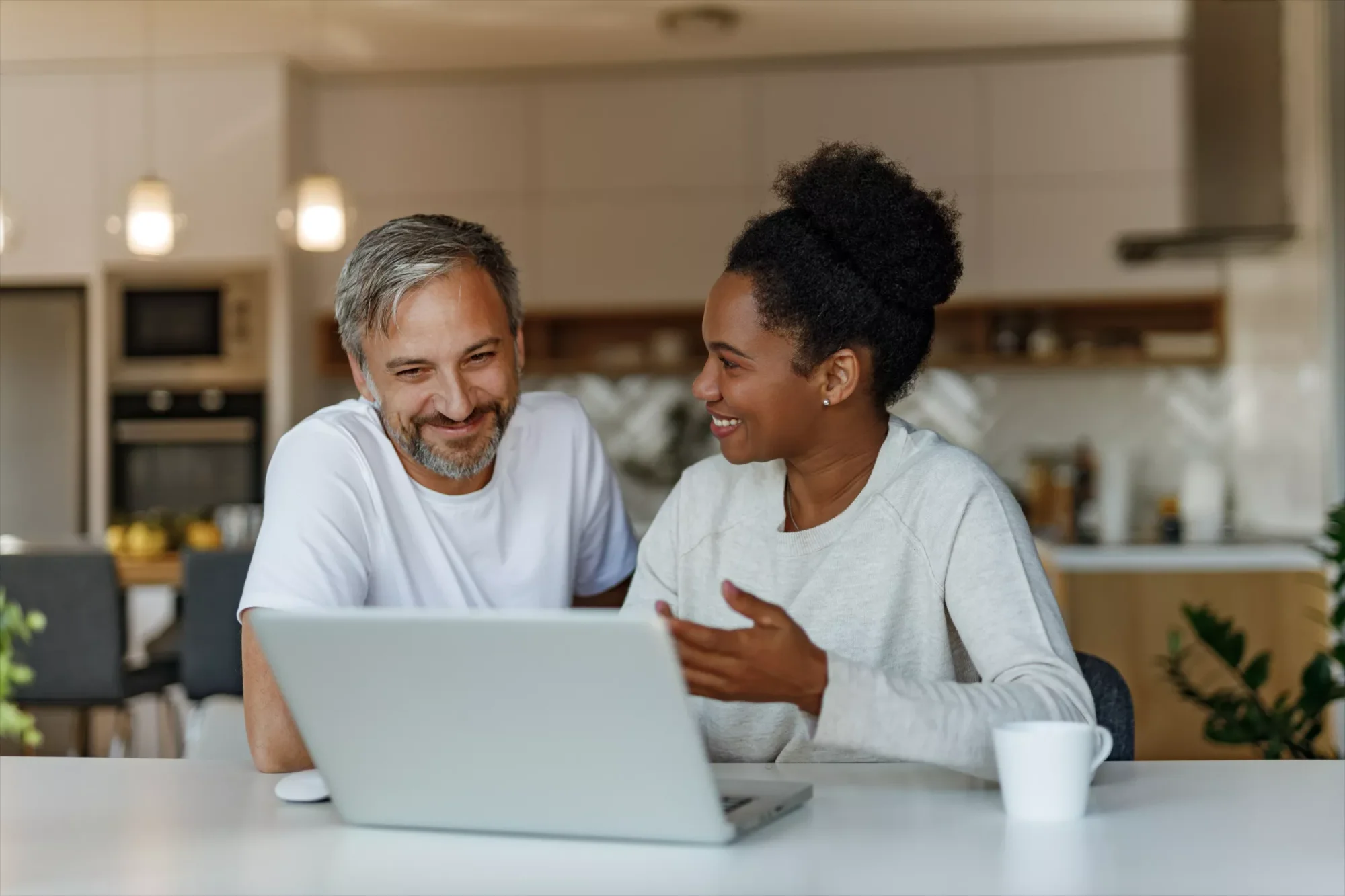A young and happy couple creating an online estate plan with LegalZoom in their kitchen.