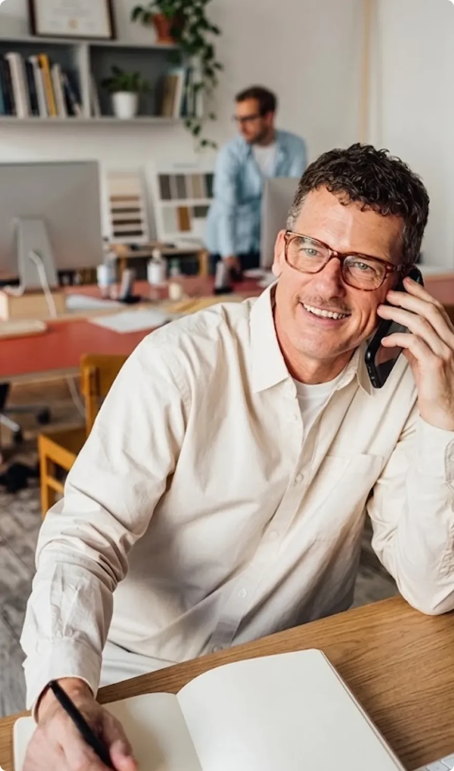 A man works and chats on the phone in a cafe