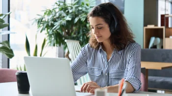 Woman with headphones working on laptop