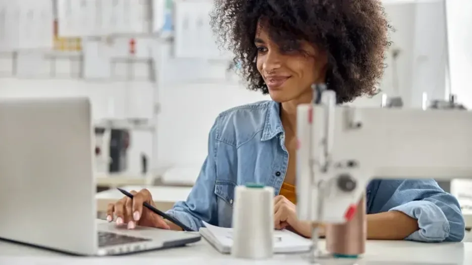 A woman seated at a desk performs a web search on her laptop. You can find online will templates at LegalZoom and other legal service websites. 