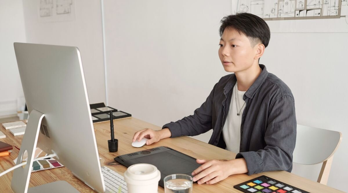 A consultant sits at their computer and communicates with clients of their consulting business.