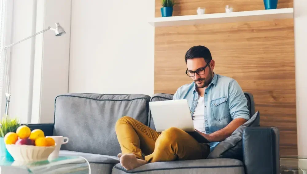 A man sitting in living room with his laptop writing a LegalZoom will.