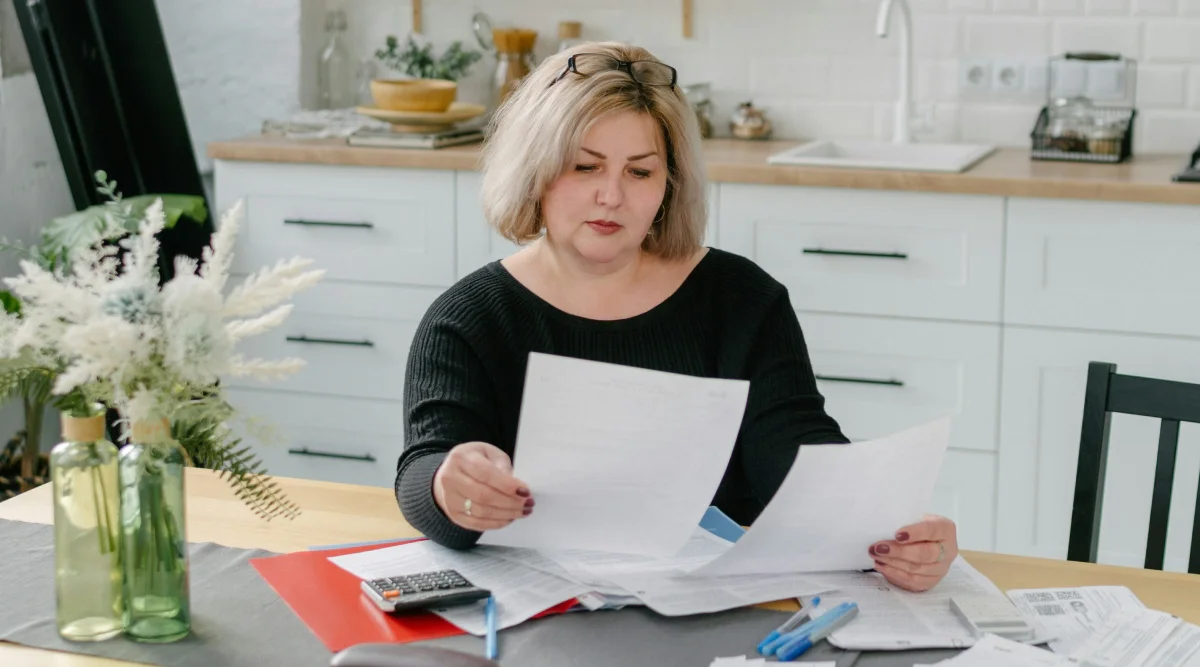 Woman reviewing documents at a kitchen table