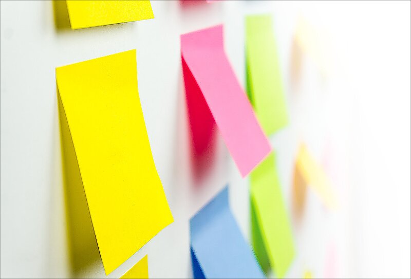 A close-up view of a whiteboard with sticky notes on it. 