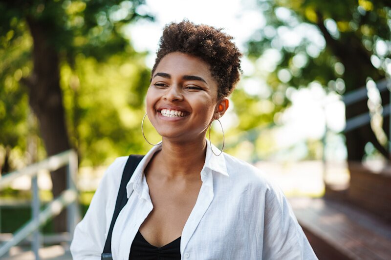A young woman is looking at the camera smiling. 