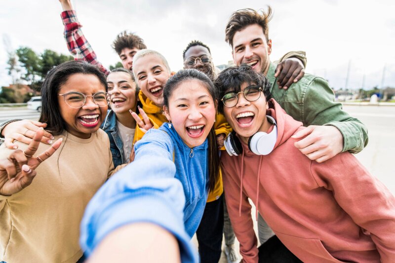 A group of young people huddled together smiling.