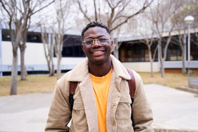 A young man is smiling at the camera. 