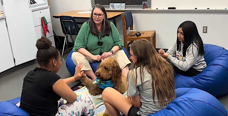 Dr. Larson and her therapy dog, Winston work with a group of students.