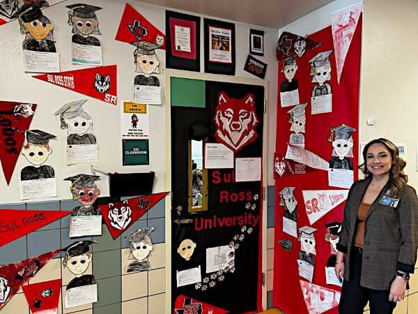 School counselor, Rosie Rodriguez poses in front of a wall her students' work.