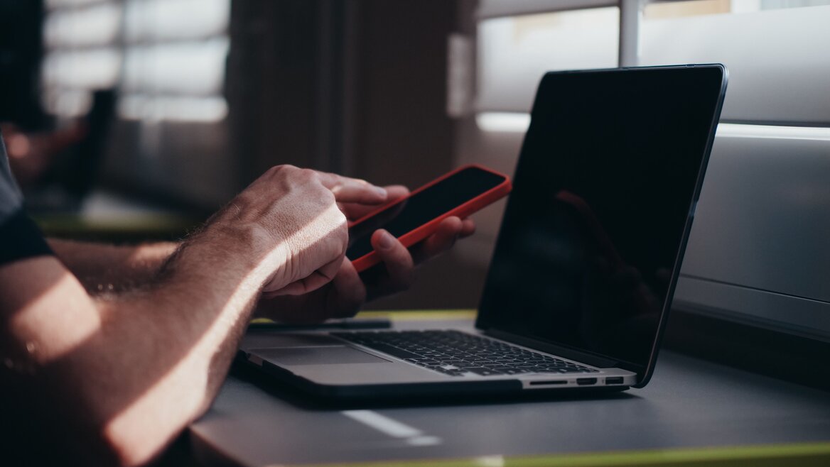 A man using gadgets to safeguard his credentials
