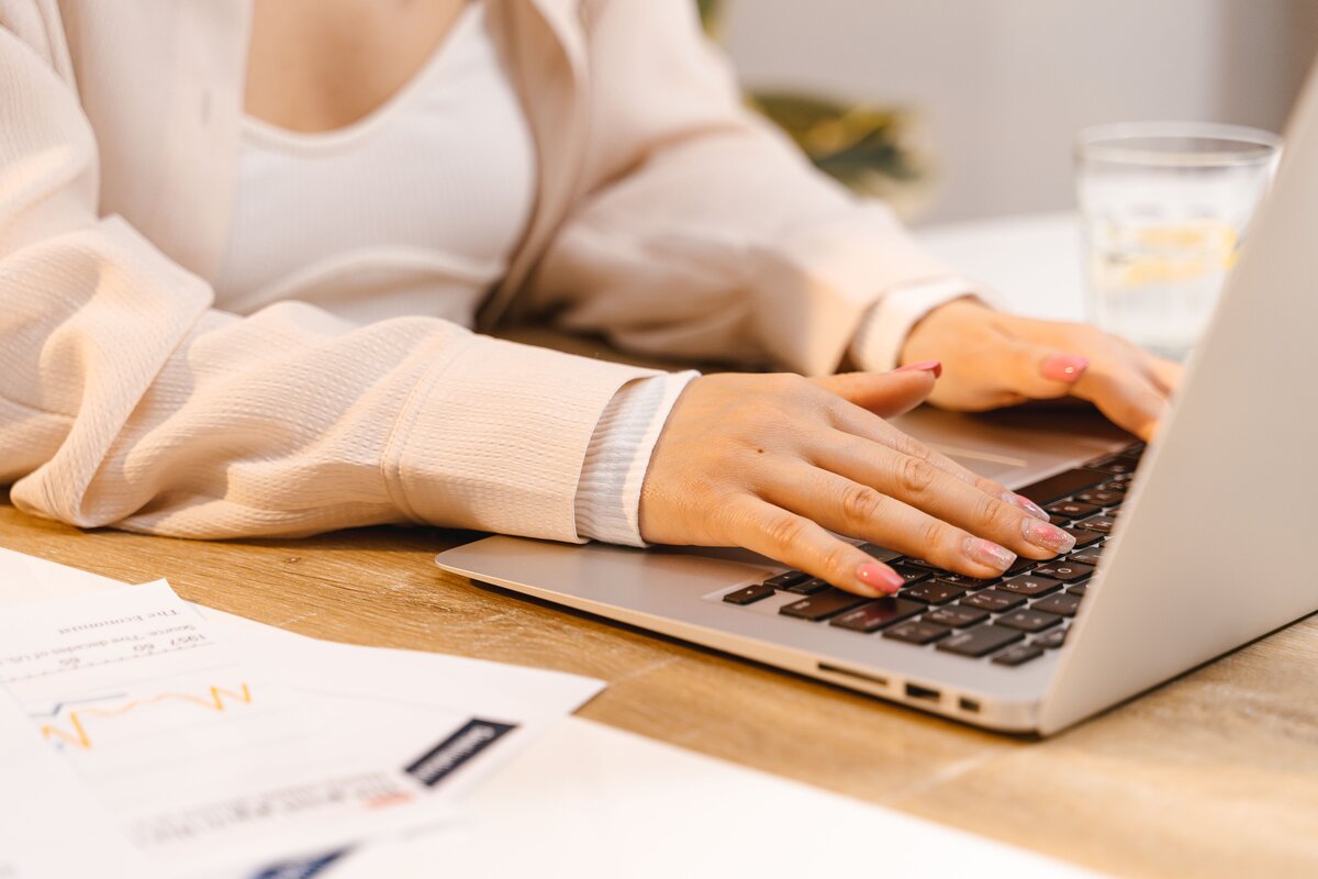 A self-employed woman using an HMRC-compliant accounting software dashboard for Making Tax Digital.