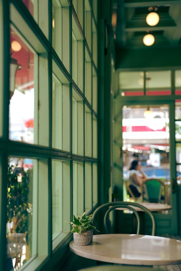 GREEN WINDOW WITH FLOWER ON TABLE