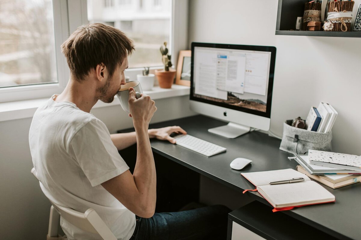man sipping coffe in his desk 