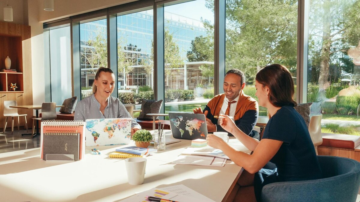 three people with three laptops talking