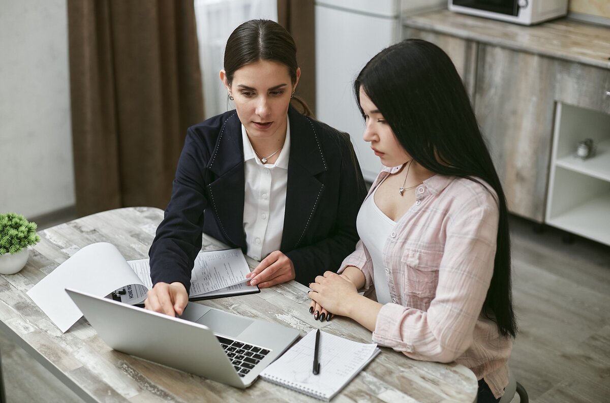 Two colleagues discussing digital tax correspondence together
