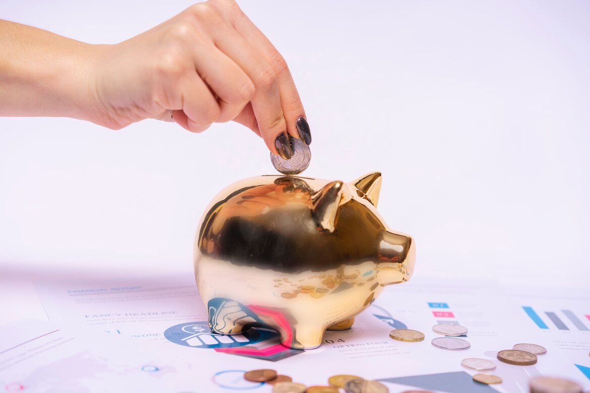 Coin being added to a piggy bank, representing the UK Personal Savings Allowance