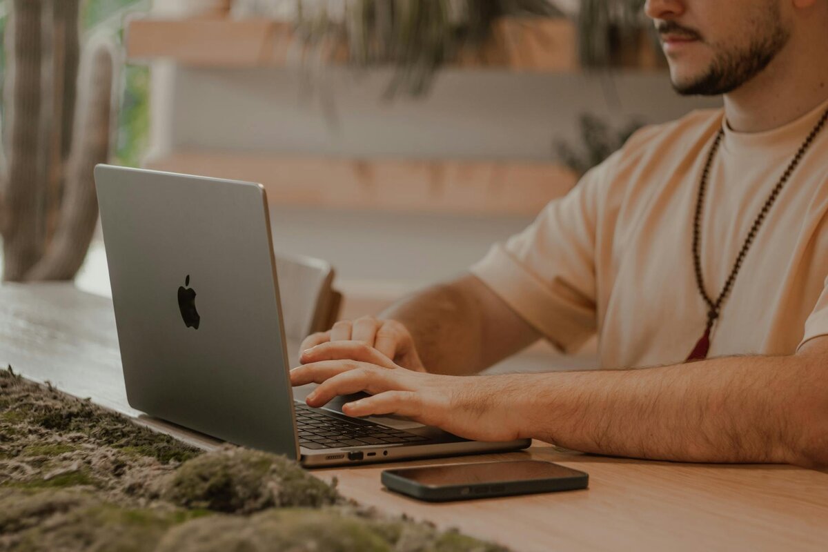 man on laptop with phone