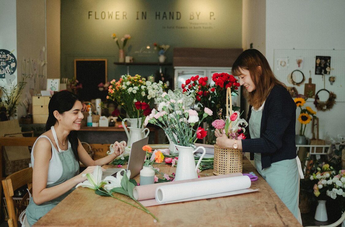 two ladies at a table with flowers 