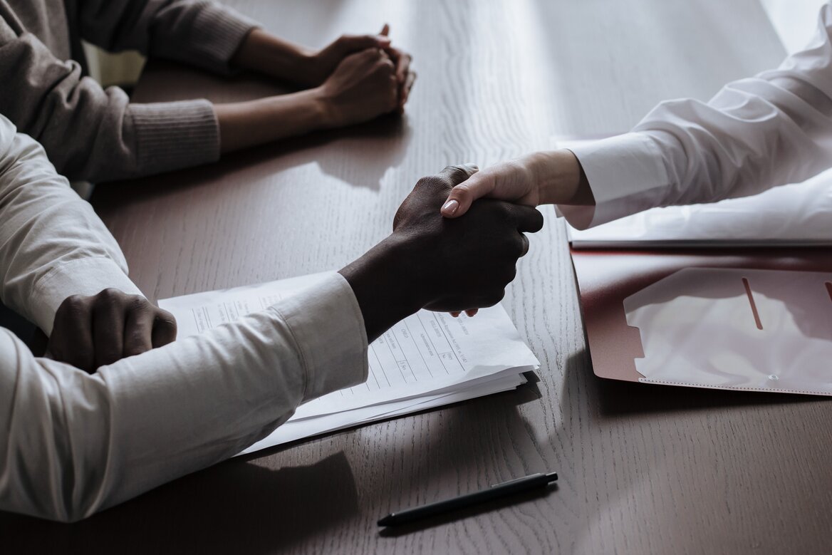 Settlor and beneficiary signing with an legal aide 