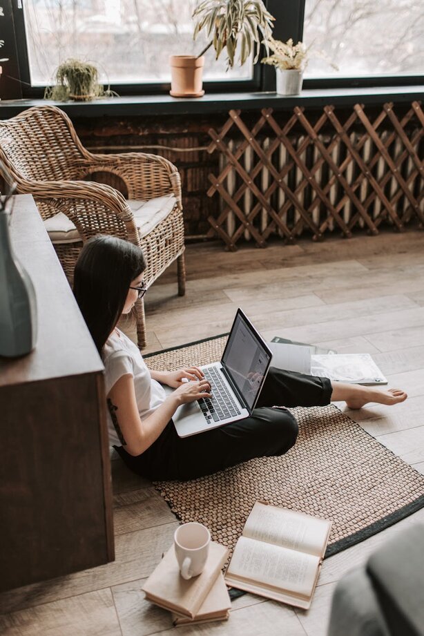 Woman sitting on the floor with a laptop 