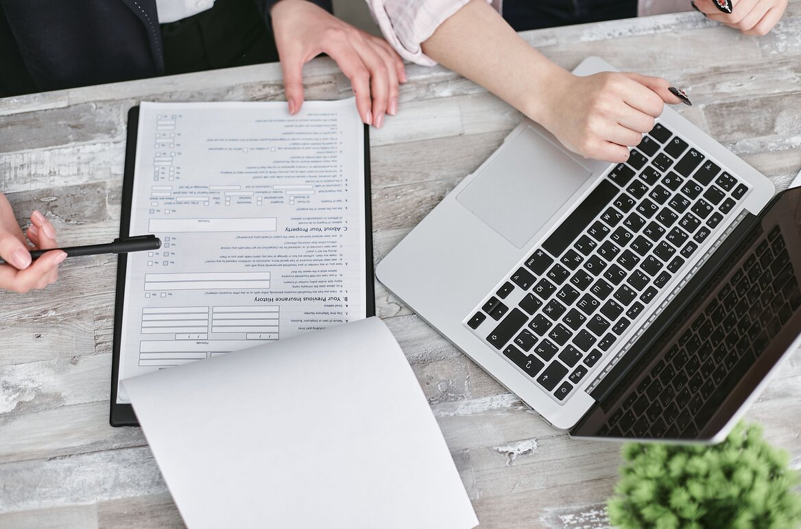Person reviewing official tax documents alongside a laptop