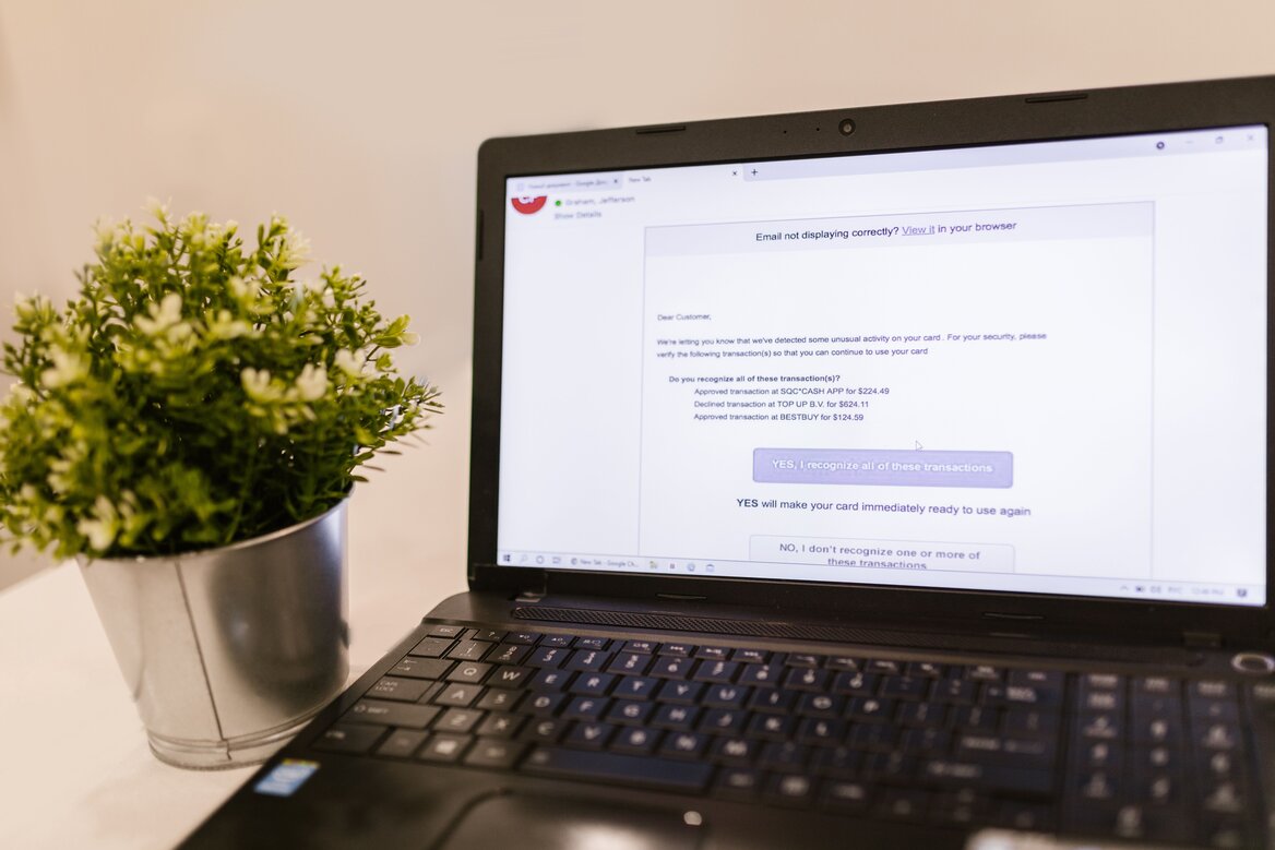 Laptop screen displaying suspicious phishing email warning about HMRC tax refund scam