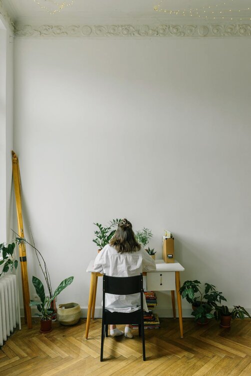 lady on laptop facing a wall