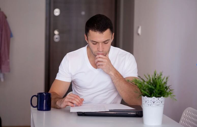 Man reviewing self assessment tax documents at home