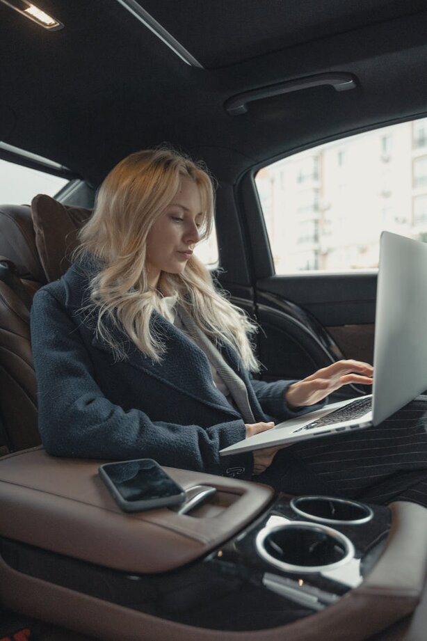 lady in her car with a laptop