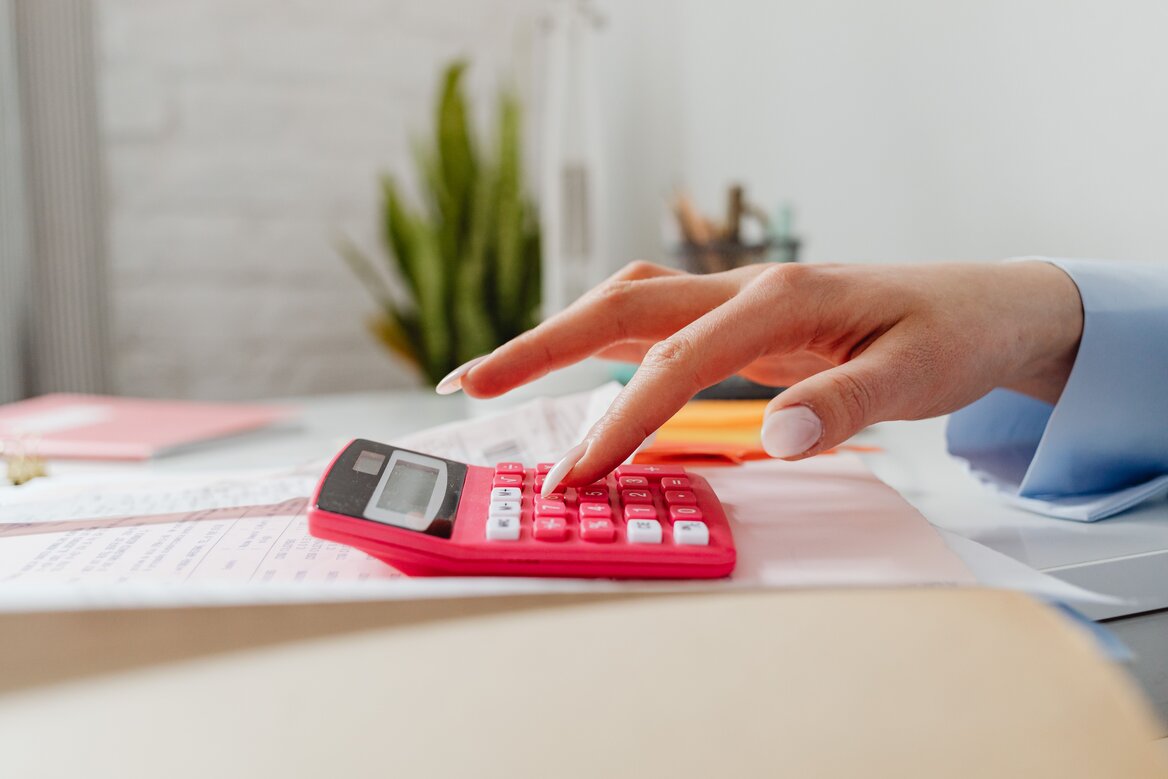 Close-up of a hand using a calculator to work out business expenses for Self Assessment