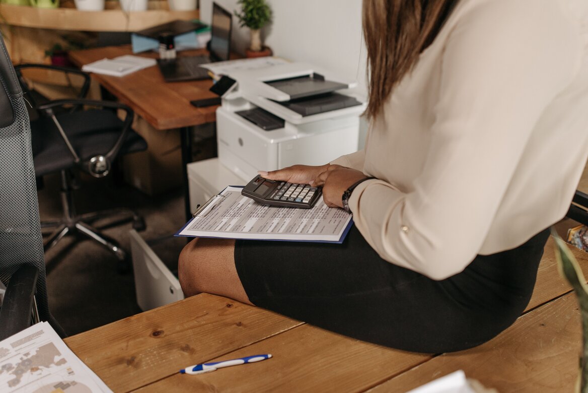 Woman sitting on a table checking her income tax options